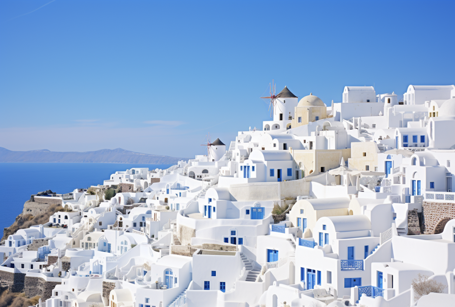 Whitewashed buildings with blue domes above the Aegean Sea
