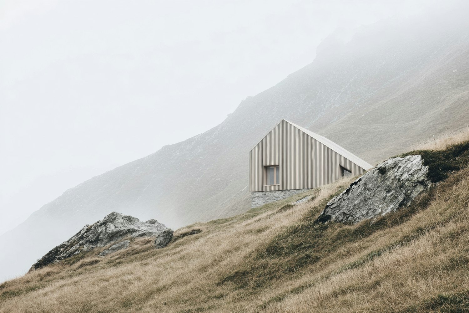 A small wooden cabin on a misty hillside
